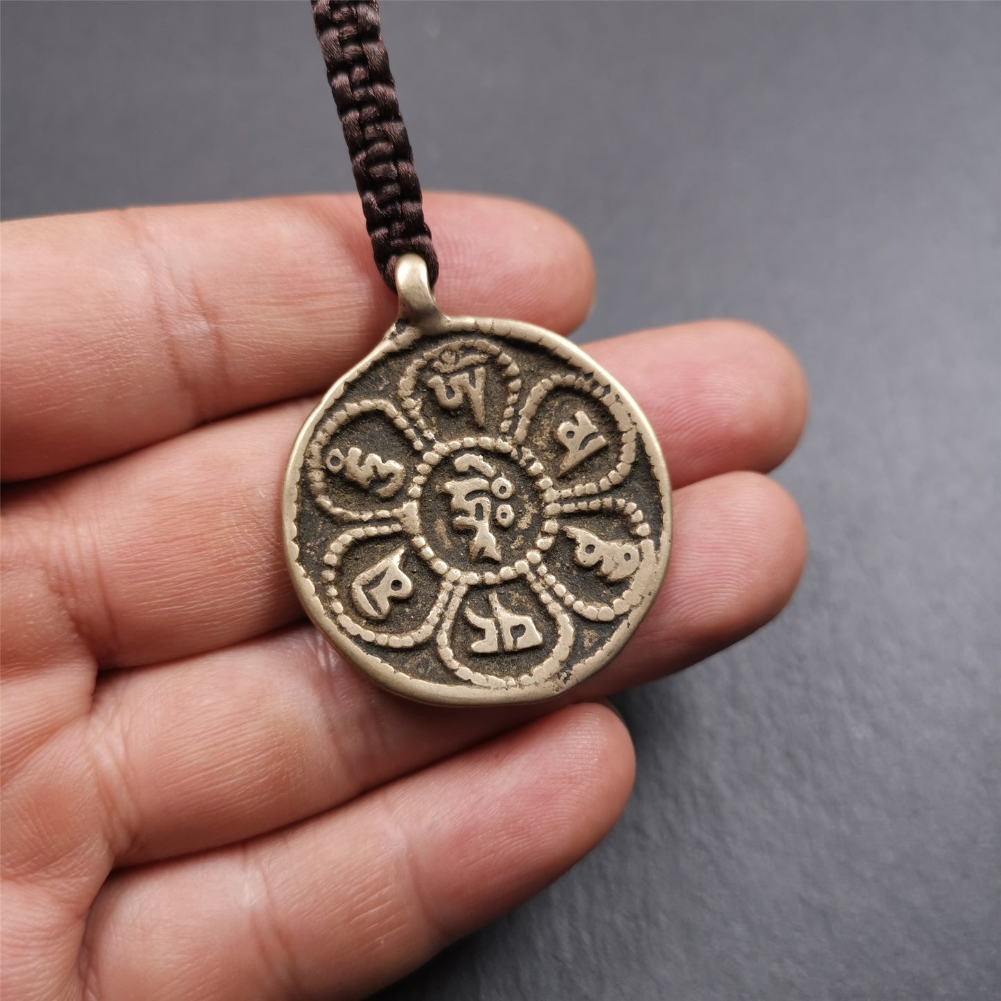This badge was made by Tibetan craftsmen and come from Hepo Town, Baiyu County, the birthplace of the famous Tibetan handicrafts. It is round badge,made of brass, 1.38 inches,carved with mantra of chenrezig OM MANI PADME HUM.