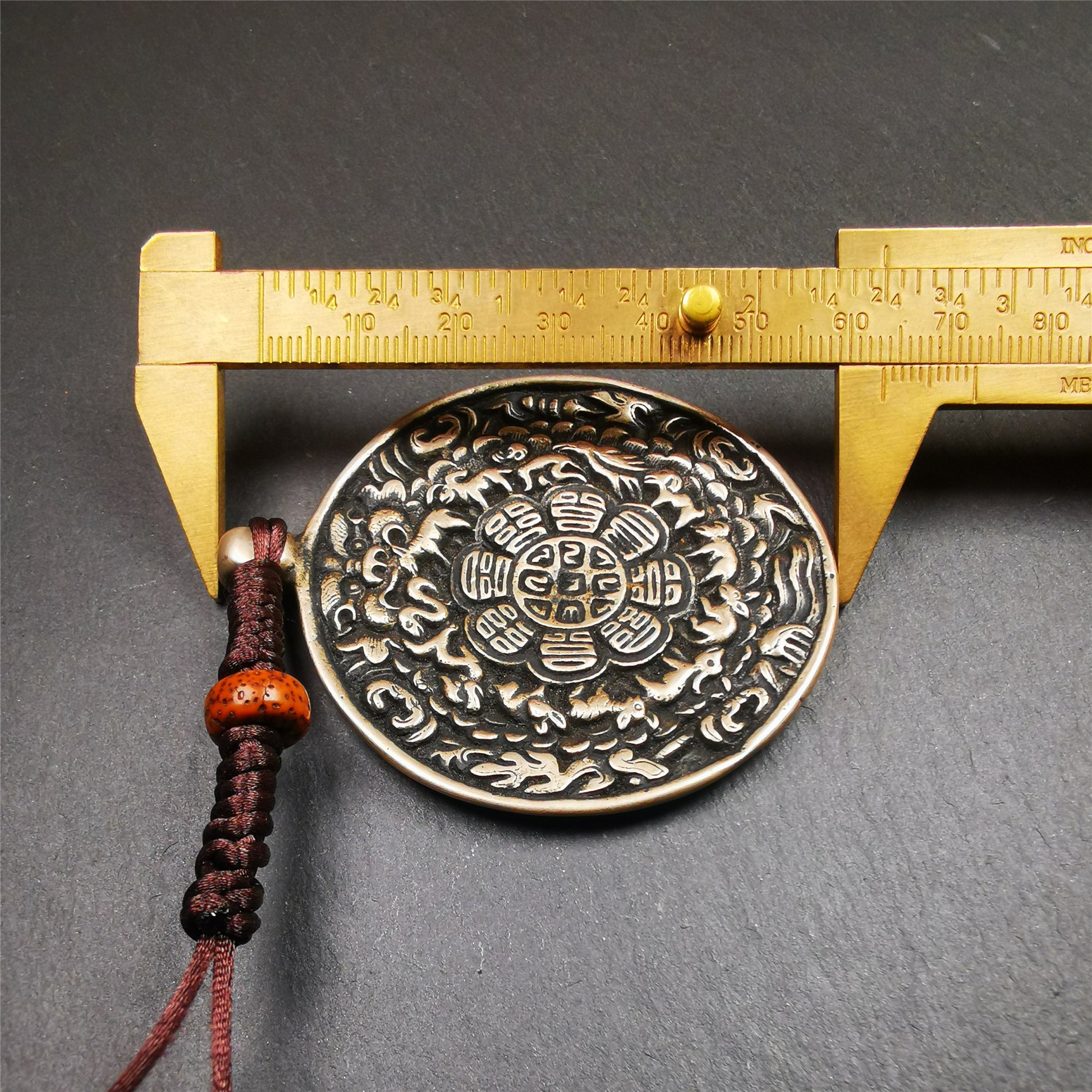 This type of melong amulet was made by Tibetan craftsmen and come from Hepo Town, Baiyu County, the birthplace of the famous Tibetan handicrafts,blessed by lama from Rejia Monastery,about 30 years old. It is made of lima brass,round shape,2.16 inches