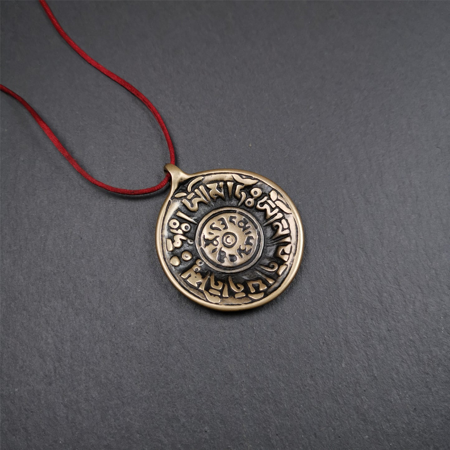 This Om badge amulet was collected from Yushu City Tibet,about 50 years old. It is round shape,made of lima brass, 1.58 inches,carved with mantra of chenrezig OM MANI PADME HUM. You can make it into a necklace, or a keychain, pendant