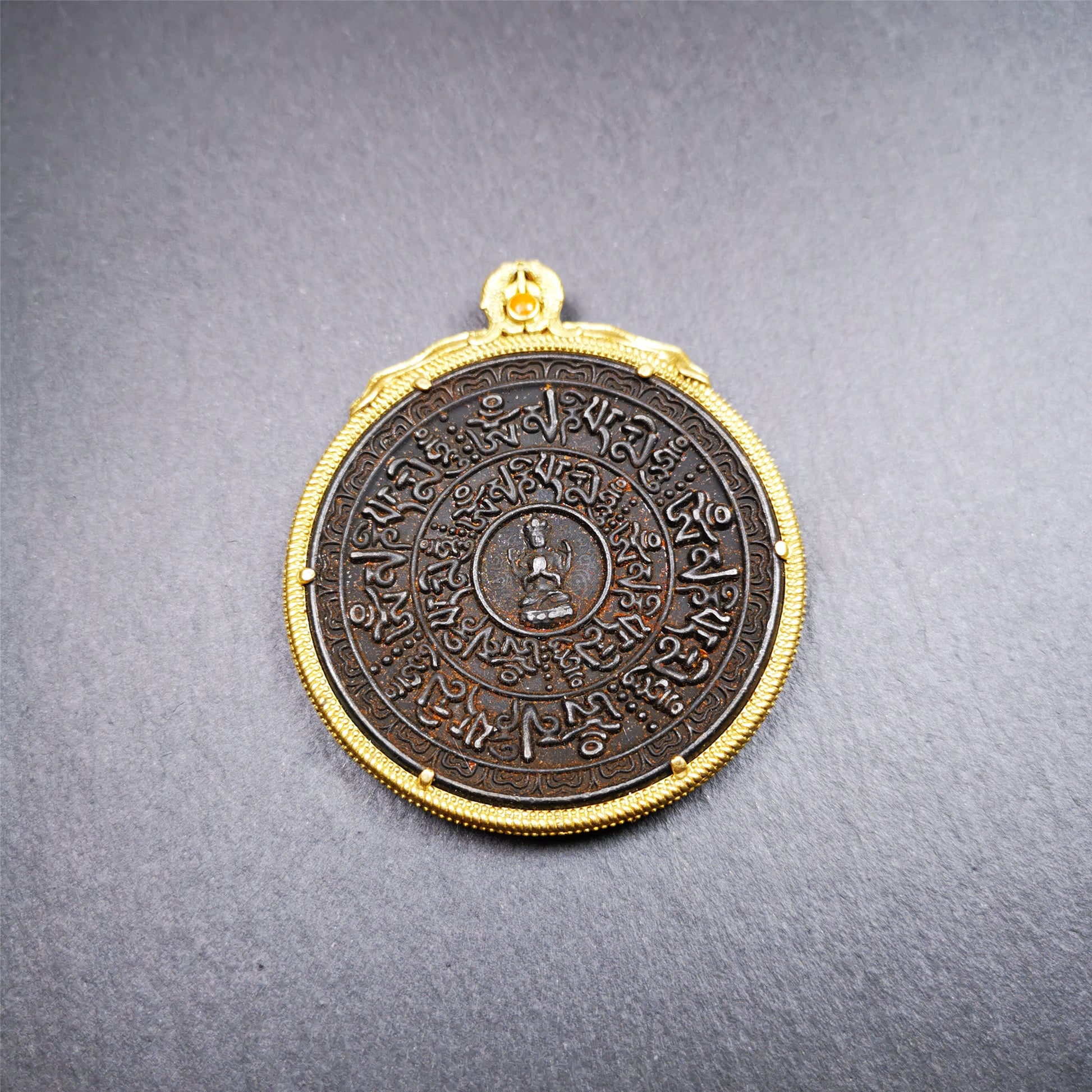 This badge was made by Tibetan craftsmen and come from Hepo Town, Baiyu County,Tibet. It is made of thokcha, edging with copper, 2.1 diameter. The mantra Om Mani Padme Hum is arranged in concentric circles around the chenrezig.