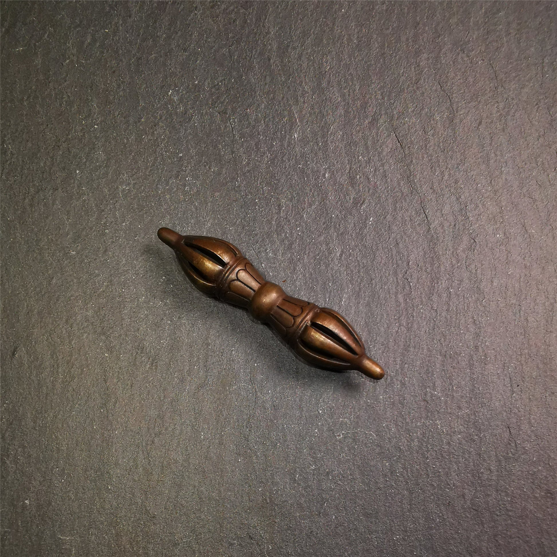 This unique vajra pendant was handmade by Tibetan craftsmen from Tibet in 1990s,from Hepo Town, Baiyu County, the birthplace of the famous Tibetan handicrafts. It is nine-pronged Vajra,made of copper, brown color,2.76 inches length.