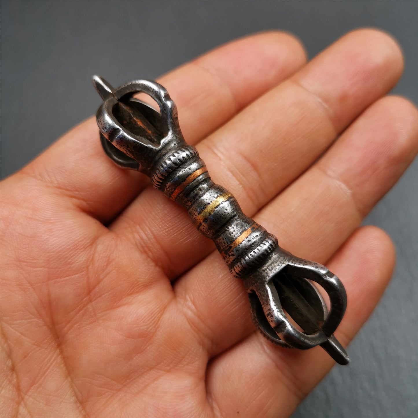 This unique vajra pendant was handmade by Tibetan craftsmen from Tibet in 1990s,from Hepo Town, Baiyu County, the birthplace of the famous Tibetan handicrafts. It is five - pronged Vajra,made of cold iron, black color,2.95 inches length.
