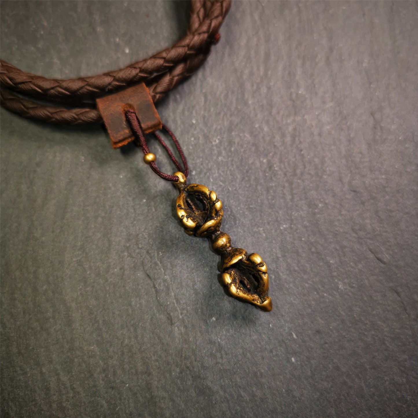 This unique vajra pendant was handmade by Tibetan craftsmen from Tibet in 1990's,from Hepo Town, Baiyu County, the birthplace of the famous Tibetan handicrafts. It is five-pronged Vajra,made of brass, 1.5 inch height.Comes with leather cord.