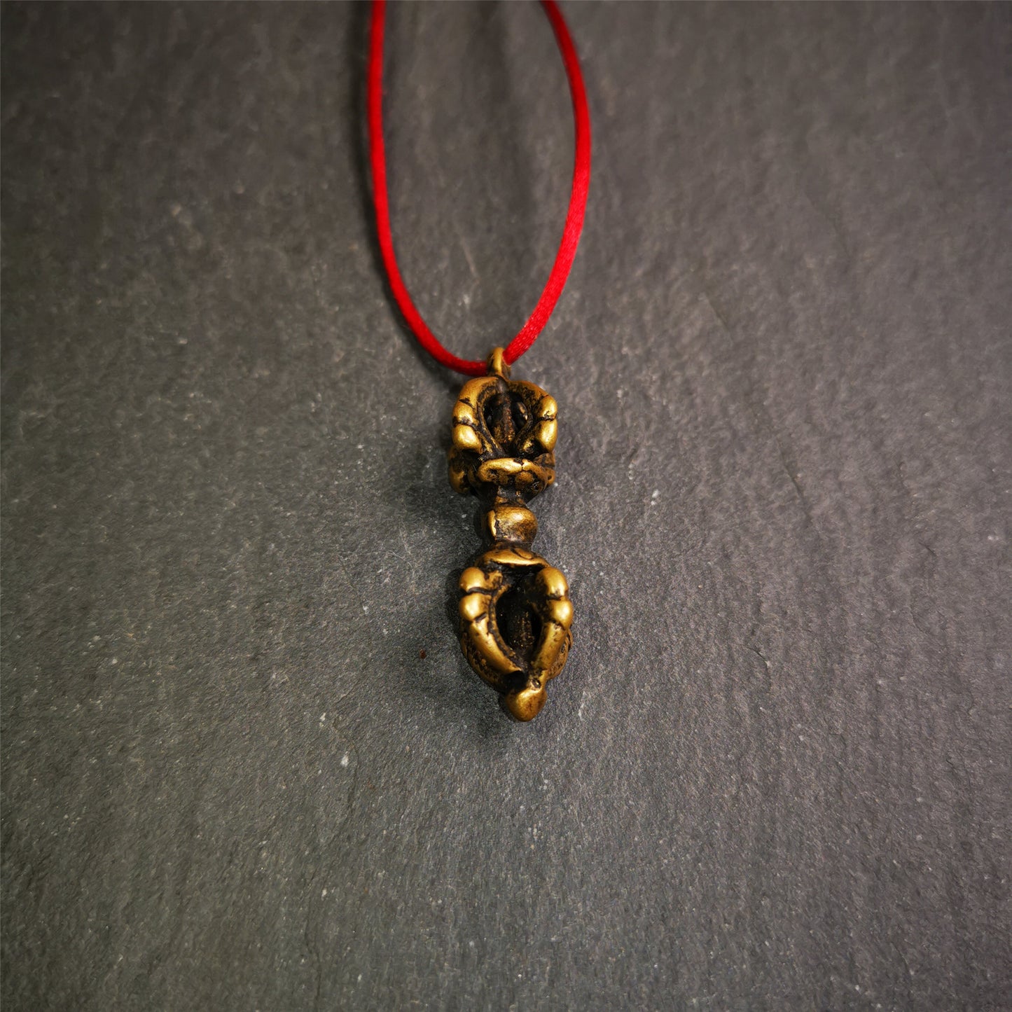 This unique vajra pendant was handmade by Tibetan craftsmen from Tibet in 1990's,from Hepo Town, Baiyu County, the birthplace of the famous Tibetan handicrafts. It is five-pronged Vajra,made of brass, 1.5 inch height.Comes with leather cord.