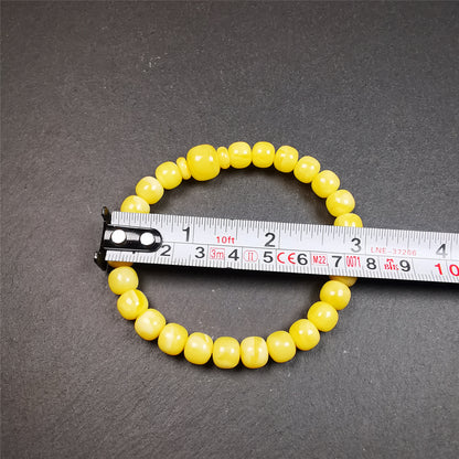 This amber beads bracelet was hand-woven by Tibetans from Baiyu County,Tibet. It is made of amber, yellow color,consists 1 main bead,25 small beads and 2 spacer beads,tie with elastic cord to fit your wrist.