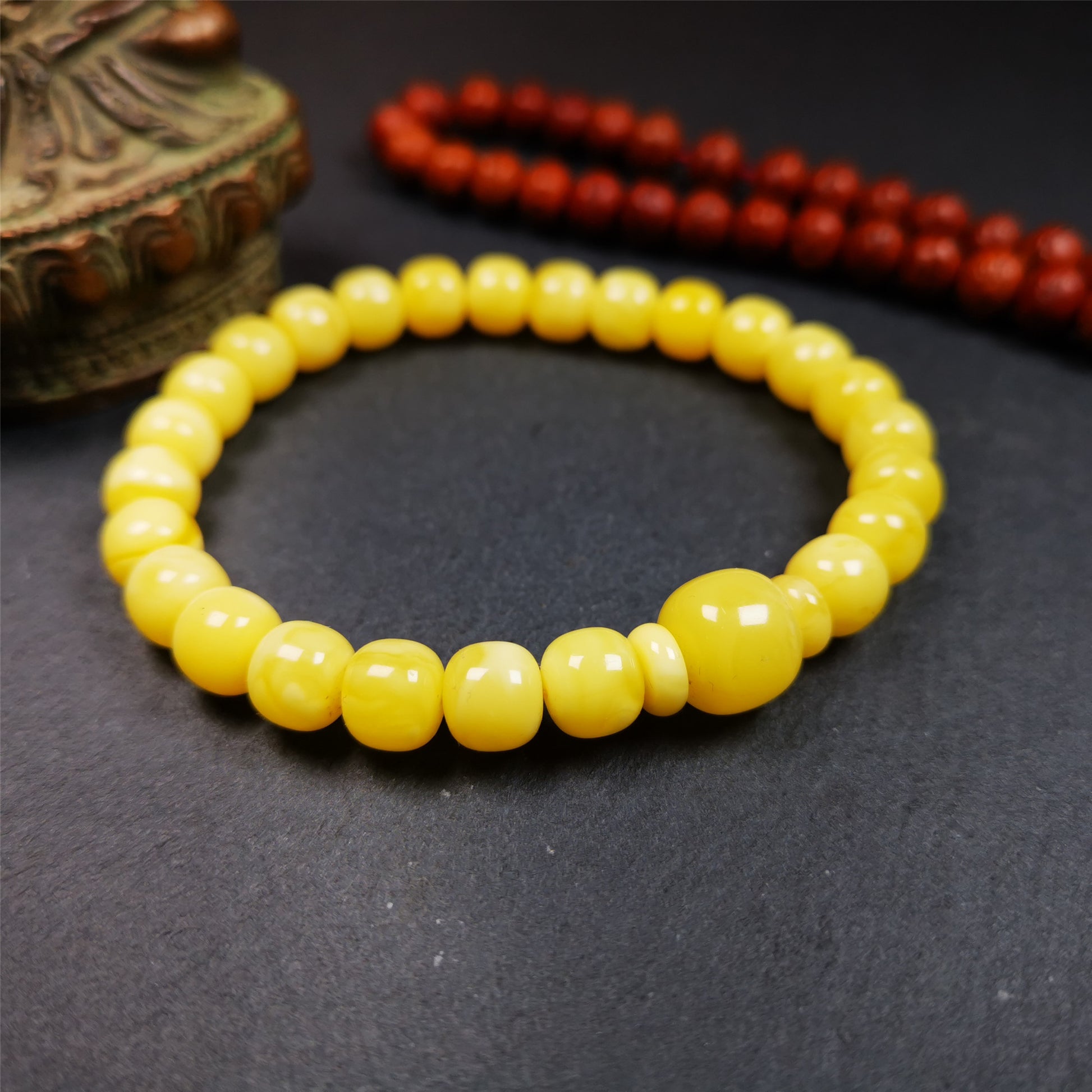 This amber beads bracelet was hand-woven by Tibetans from Baiyu County,Tibet. It is made of amber, yellow color,consists 1 main bead,25 small beads and 2 spacer beads,tie with elastic cord to fit your wrist.