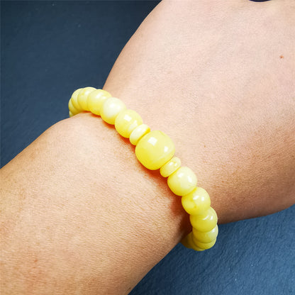 This amber beads bracelet was hand-woven by Tibetans from Baiyu County,Tibet. It is made of amber, yellow color,consists 1 main bead,25 small beads and 2 spacer beads,tie with elastic cord to fit your wrist.