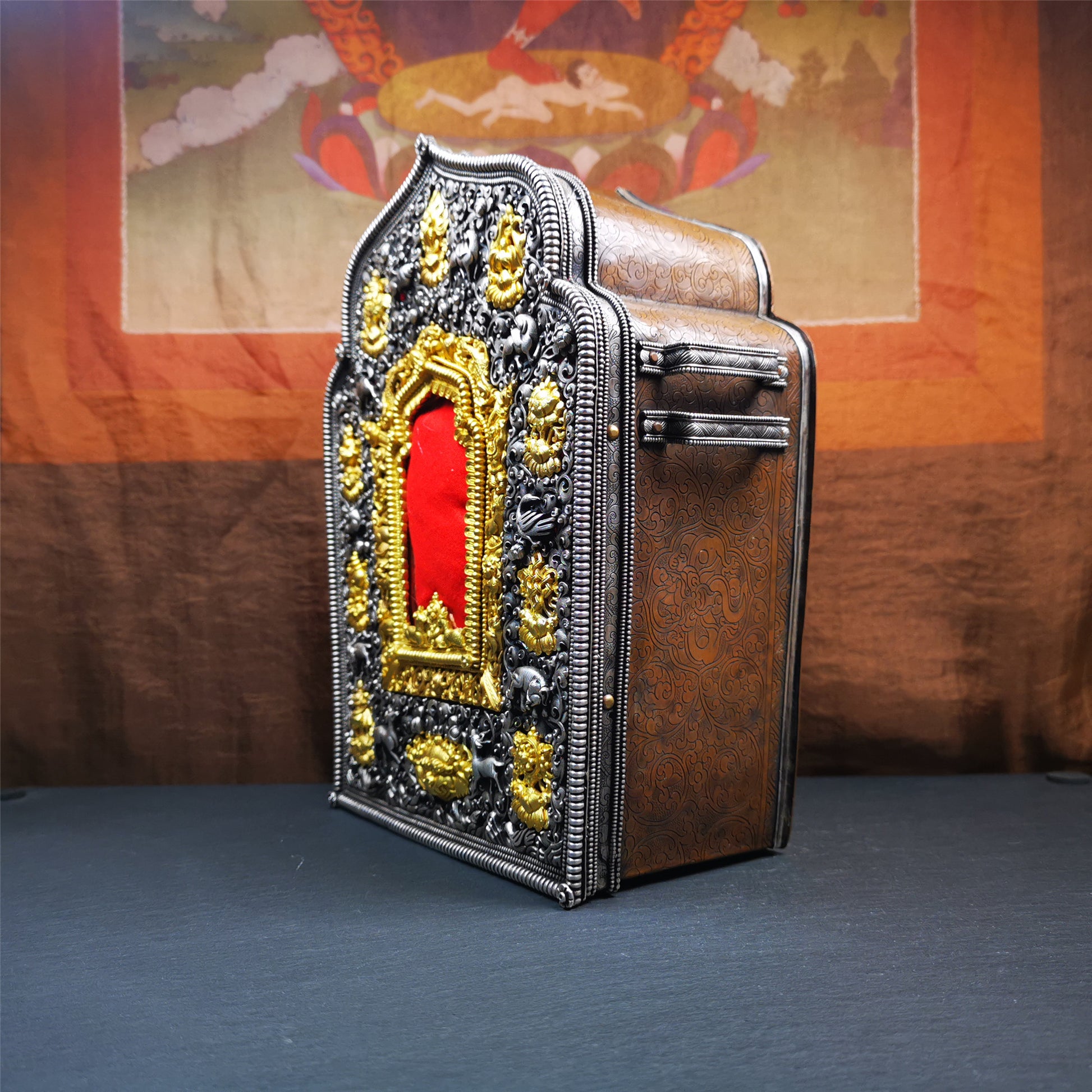 This large Gau shrine was handcrafted by Tibetan artisans from Hepo Township, Baiyu County. Each exquisite pattern on it is meticulously hand-carved,and it is embellished with the technique of gold inlay, with pure silver inlaid on the red copper material and gold-plated on the pure silver material.Its theme is Astamangala, and it features 10 mythical creatures traversing a silver-patterned meadow. The interior space of the box is quite spacious, large enough to accommodate a 12 * 8 cm Buddha statue.