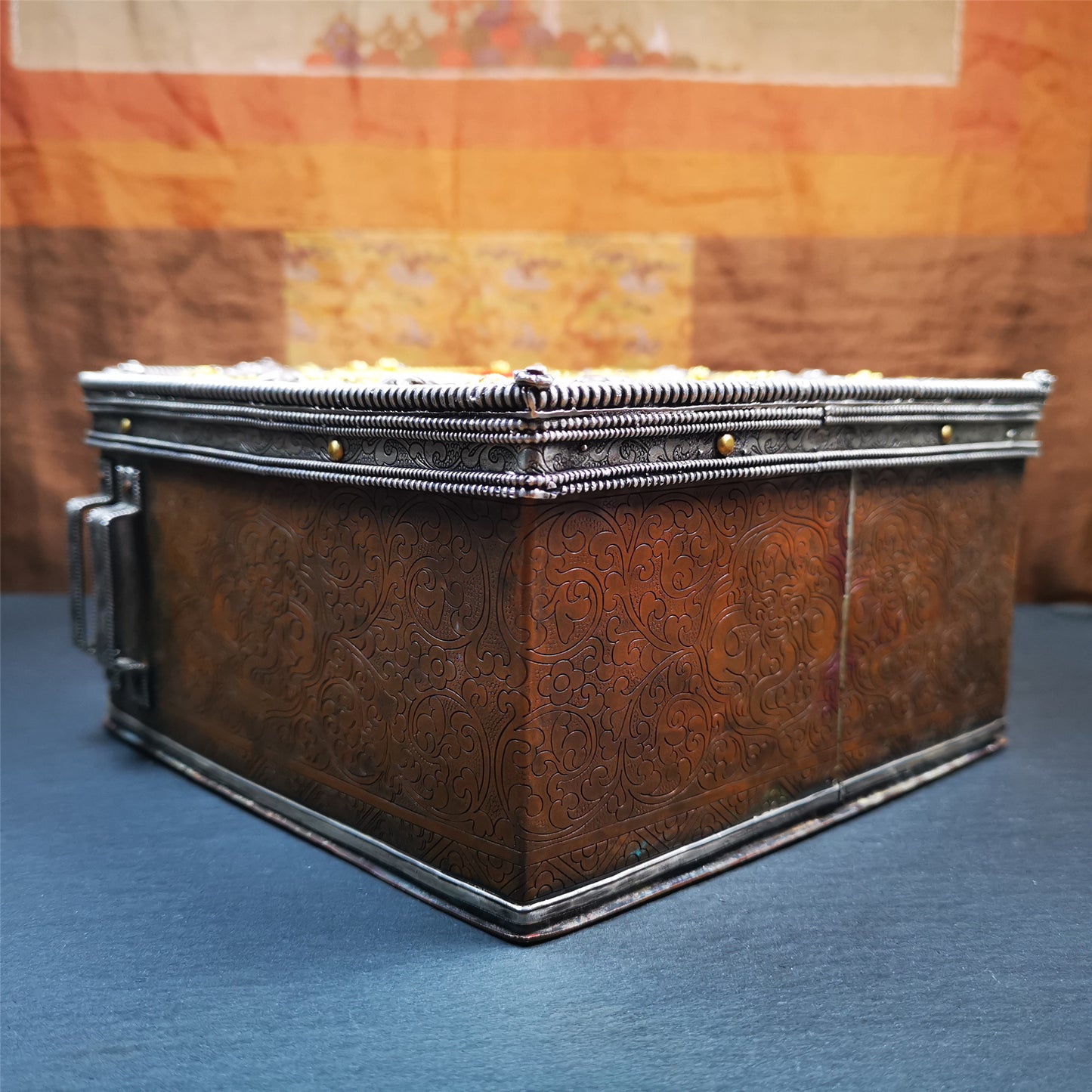 This large Gau shrine was handcrafted by Tibetan artisans from Hepo Township, Baiyu County. Each exquisite pattern on it is meticulously hand-carved,and it is embellished with the technique of gold inlay, with pure silver inlaid on the red copper material and gold-plated on the pure silver material.Its theme is Astamangala, and it features 10 mythical creatures traversing a silver-patterned meadow. The interior space of the box is quite spacious, large enough to accommodate a 12 * 8 cm Buddha statue.