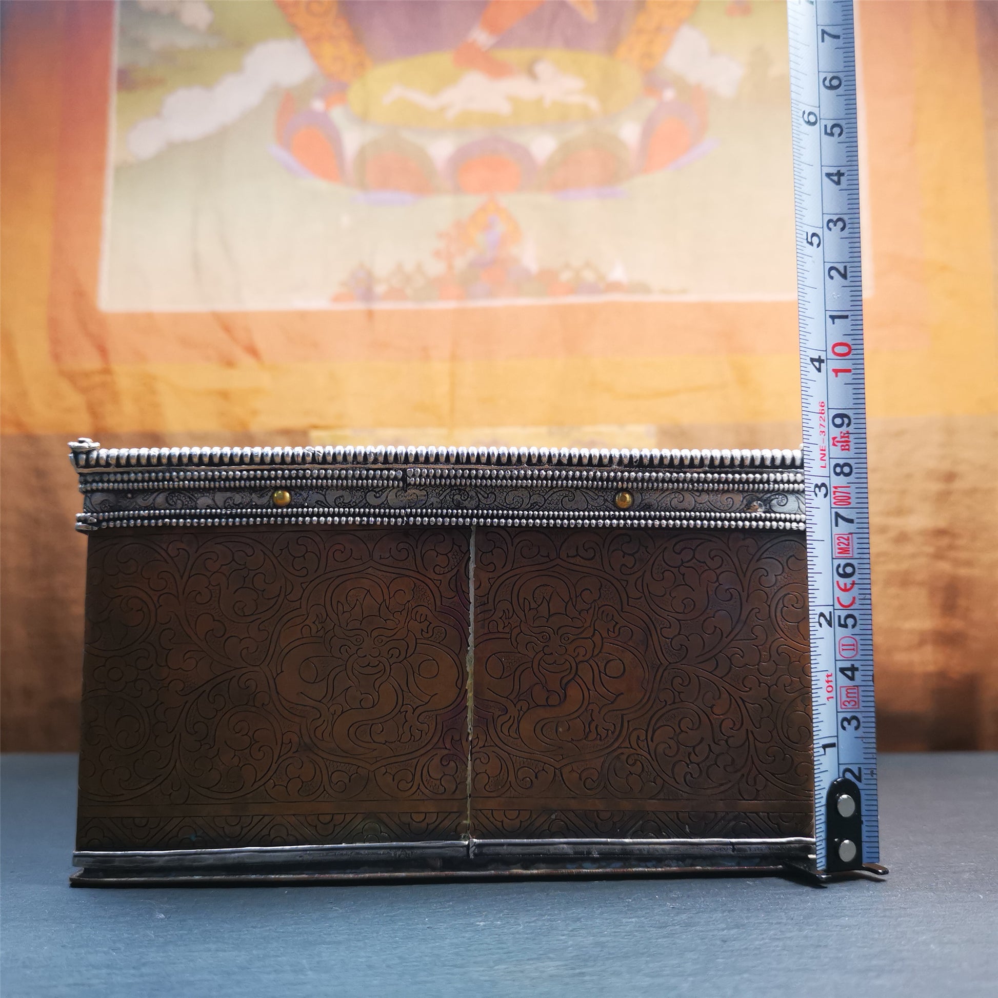 This large Gau shrine was handcrafted by Tibetan artisans from Hepo Township, Baiyu County. Each exquisite pattern on it is meticulously hand-carved,and it is embellished with the technique of gold inlay, with pure silver inlaid on the red copper material and gold-plated on the pure silver material.Its theme is Astamangala, and it features 10 mythical creatures traversing a silver-patterned meadow. The interior space of the box is quite spacious, large enough to accommodate a 12 * 8 cm Buddha statue.