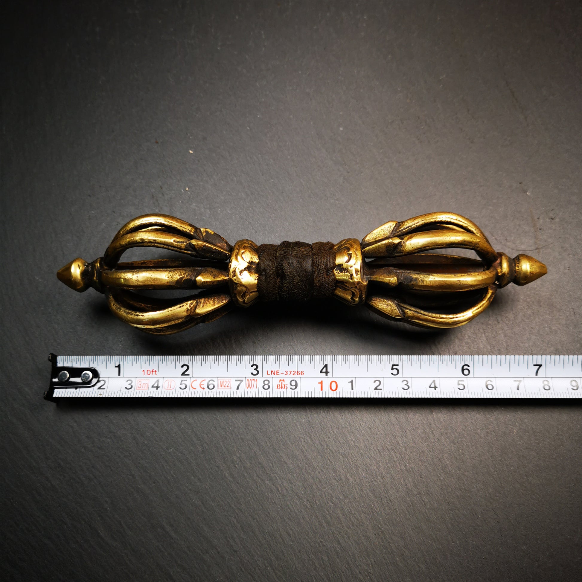 This vajra set was handmade in Nepal,using traditional techniques and materials. The Nine-pronged vajra is made of brass, and the outer box is made of wood,carved with the Tibetan letter of three karmas of word, thought , and deed The vajra can be inserted into the top of the box