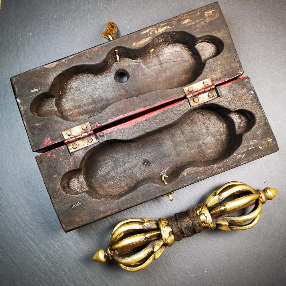 This vajra set was handmade in Nepal,using traditional techniques and materials. The Nine-pronged vajra is made of brass, and the outer box is made of wood,carved with the Tibetan letter of three karmas of word, thought , and deed The vajra can be inserted into the top of the box