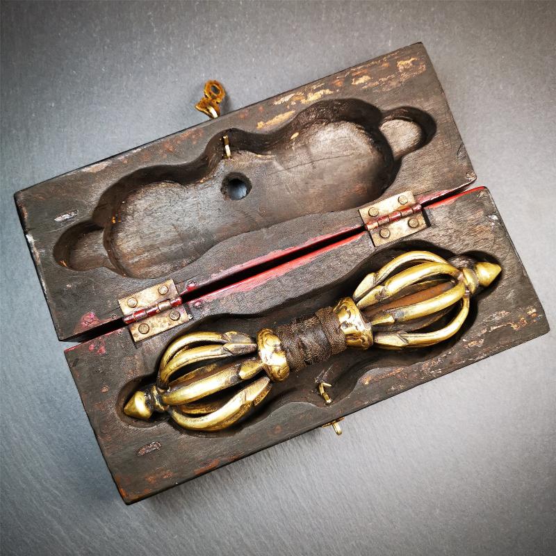 This vajra set was handmade in Nepal,using traditional techniques and materials. The Nine-pronged vajra is made of brass, and the outer box is made of wood,carved with the Tibetan letter of three karmas of word, thought , and deed The vajra can be inserted into the top of the box