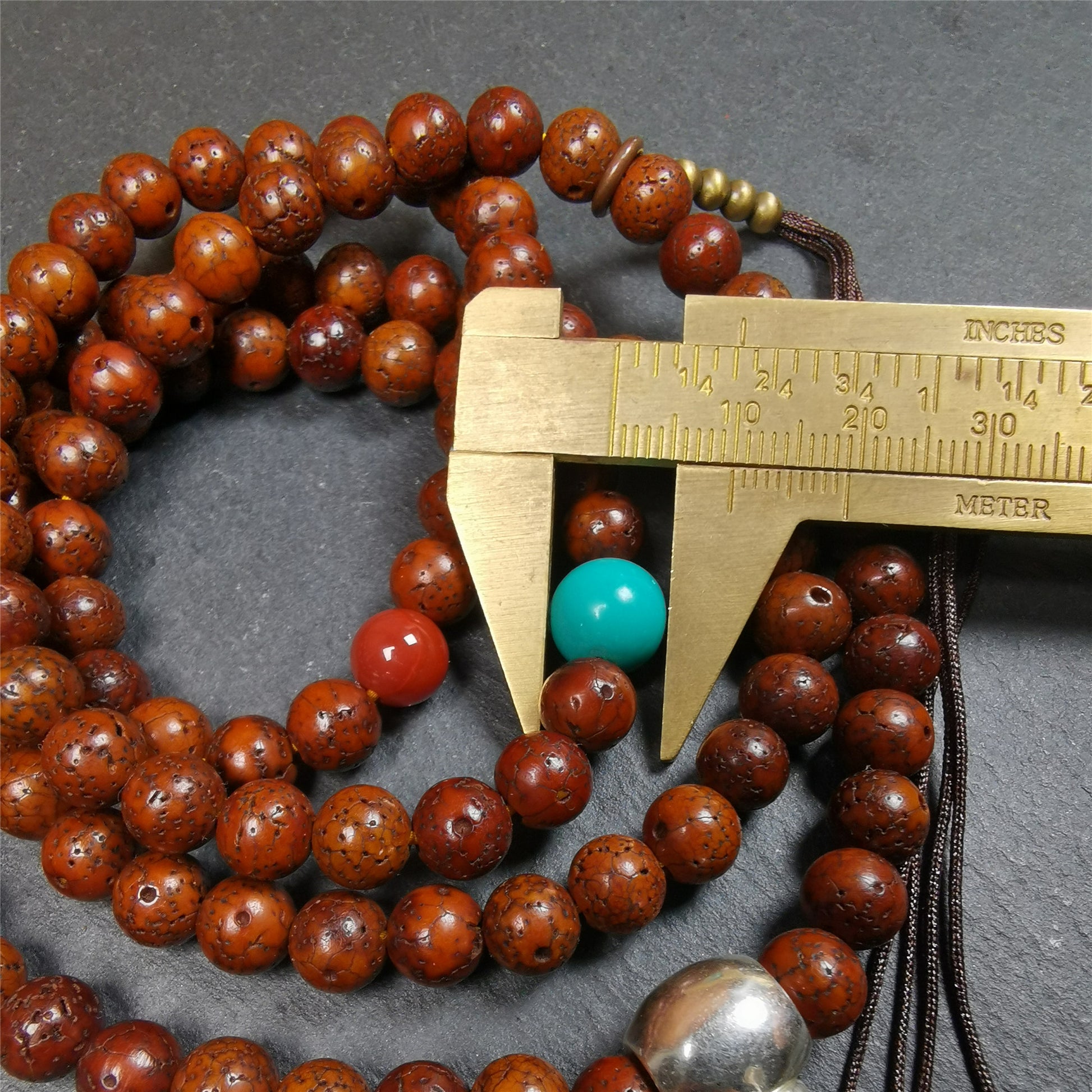This old lotus seed mala was handmade from tibetan crafts man in Baiyu County,about 30 years old,blessed by lama. It's composed of 108 pcs 8mm lotus seed beads,then add some old agate,turquoise beads,1 pair of copper bead counters,and white copper guru bead on it.