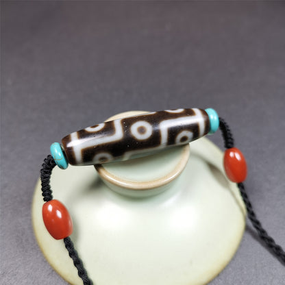 This 9 eyes dzi necklace was hand-woven by Tibetans from Baiyu County, the main bead is a 9 eyed  dzi bead, paired with 2 small agate beads and 2 turquoise spacer beads,about 30 years old.