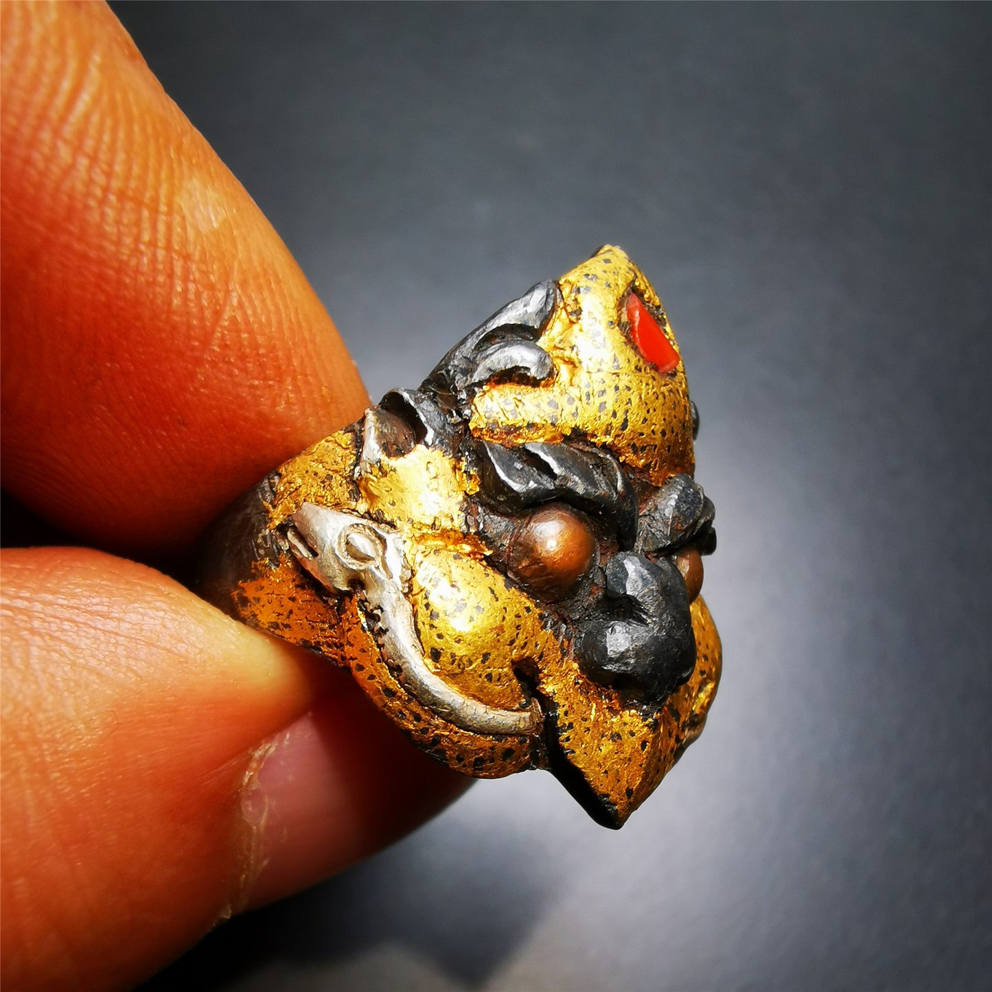 This garuda ring is made by Tibetan craftsmen for 30 years old,and come from Hepo Town, Baiyu County, the birthplace of the famous Tibetan handicrafts.  It is crafted from a variety of materials including solid gold, sterling silver, cold iron, brass and agate,using traditional Tibetan craftsmanship to carry out multiple carvings and gold filled craftsmanship, inlaid with gold, silver, copper on the base of cold iron, together to create a classic image in Buddhism-Garuda-golden winged bird.