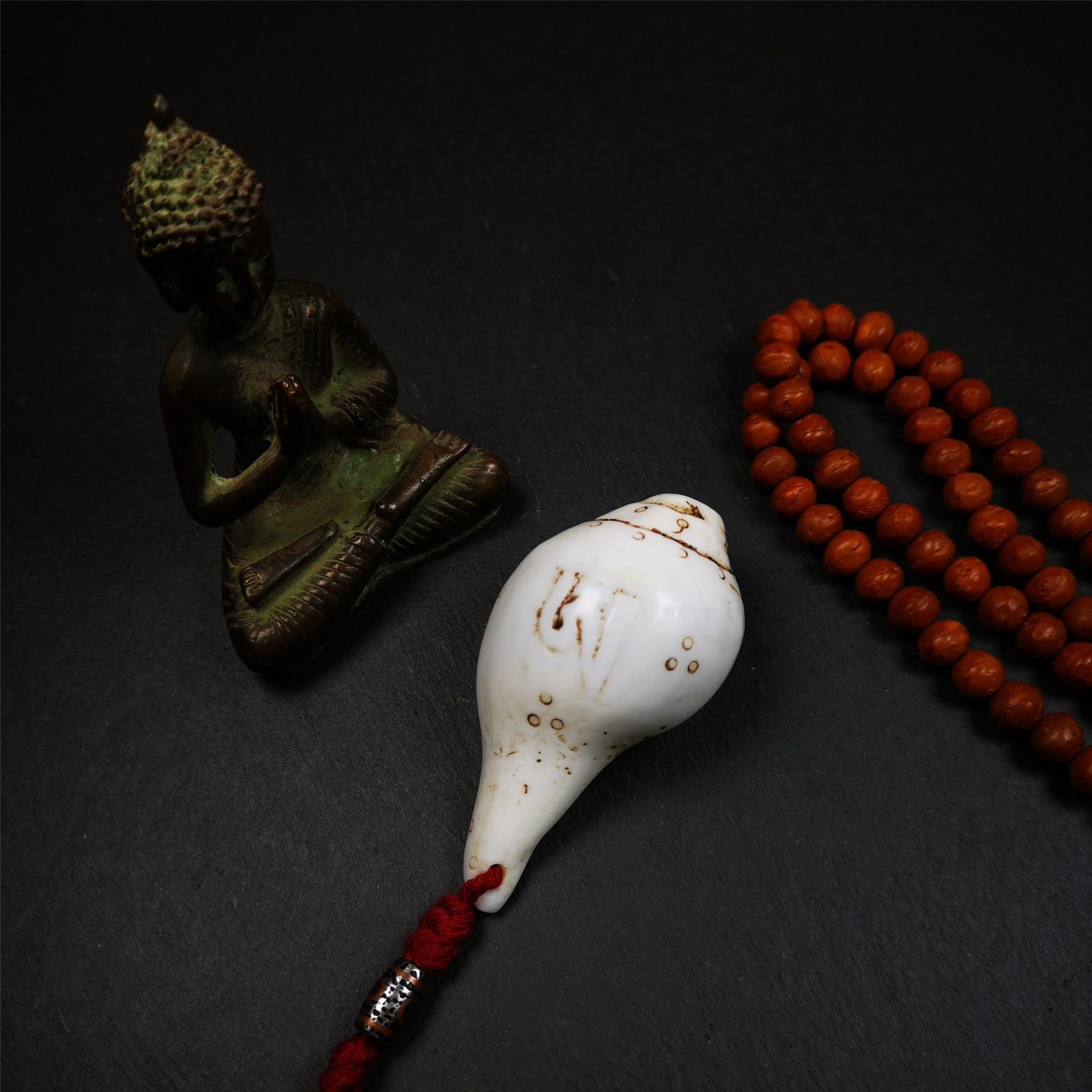This conch ritual was hand carved by Tibetan craftsmen,collected from Gengqing Monastery,about 40 years old. It's made of conch, entirely hand-carved with tibetan letter OM and mantra dots,and there is an iron dzi bead hanging at the tail,very beautiful.