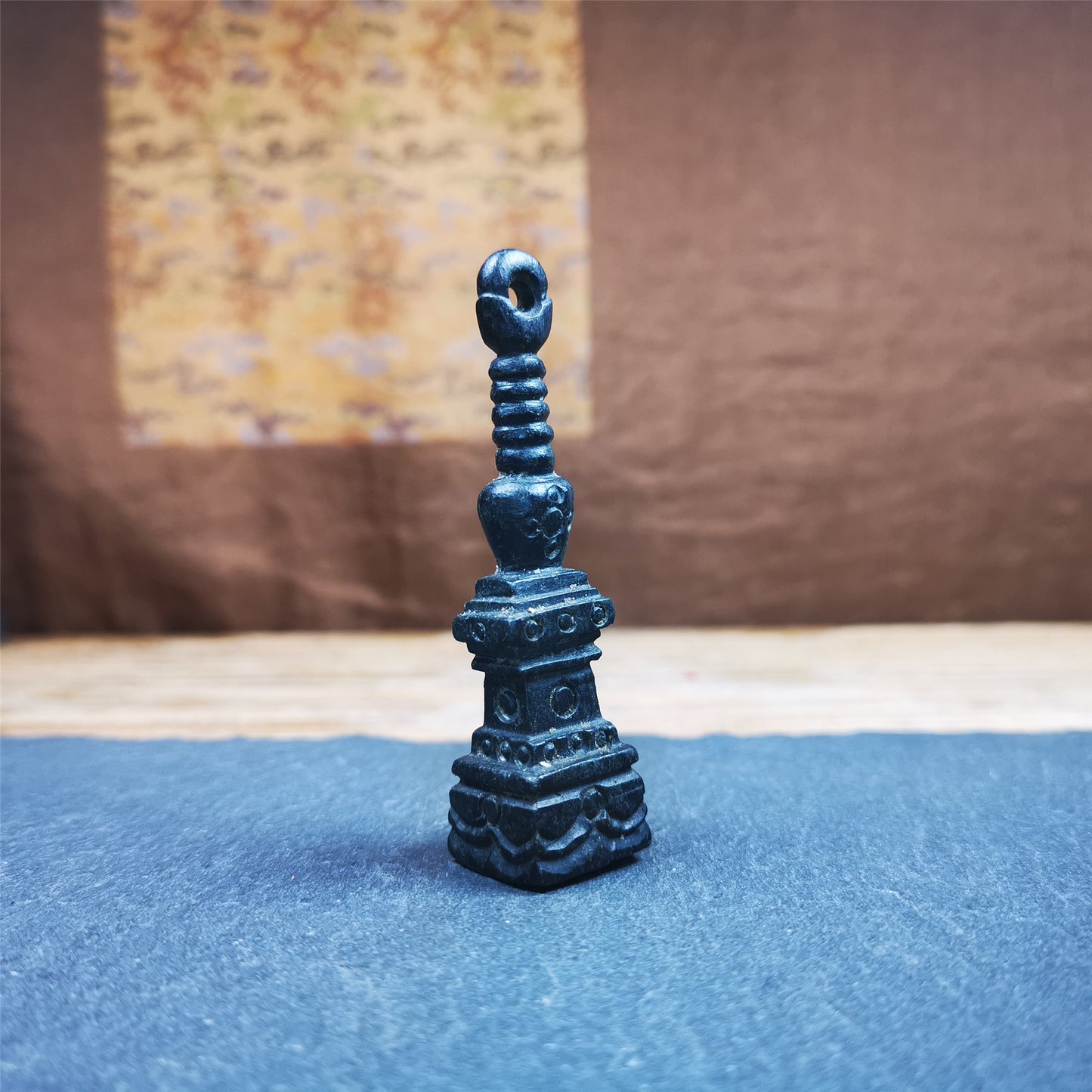 This beautiful stupa pendant is hand carved by Tibetan craftsmen from Tibet in 2000's. From Hepo Town, Baiyu County, the birthplace of the famous Tibetan handicrafts. It was made of obsidian, all black color,2.95 inches height. At the bottom of it is engraved with the Tibetan word OM.