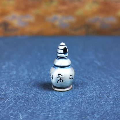 This beautiful stupa gau shrine was handmade by Tibetan craftsmen from Tibet in 2000s. It was made of silver and brass,the OM MANI PADME HUM mantra engraved on its side, the top bottle cap can be opened and you can place offerings inside,like mani rilbu or zung Consecration. The om mantra at the bottom can be used as a seal. You can make it into a necklace, or a keychain, or just put it in your shrine or altar.