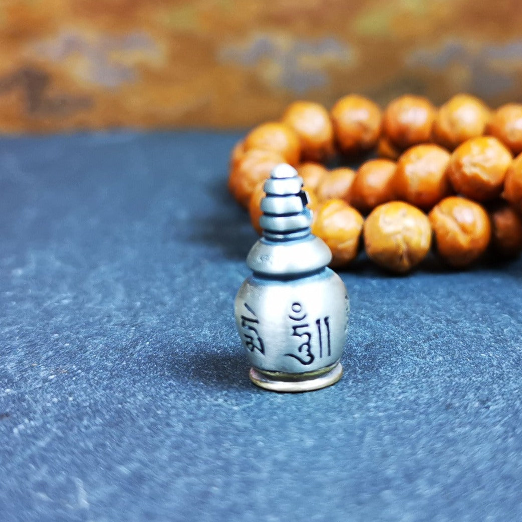 This beautiful stupa gau shrine was handmade by Tibetan craftsmen from Tibet in 2000s. It was made of silver and brass,the OM MANI PADME HUM mantra engraved on its side, the top bottle cap can be opened and you can place offerings inside,like mani rilbu or zung Consecration. The om mantra at the bottom can be used as a seal. You can make it into a necklace, or a keychain, or just put it in your shrine or altar.