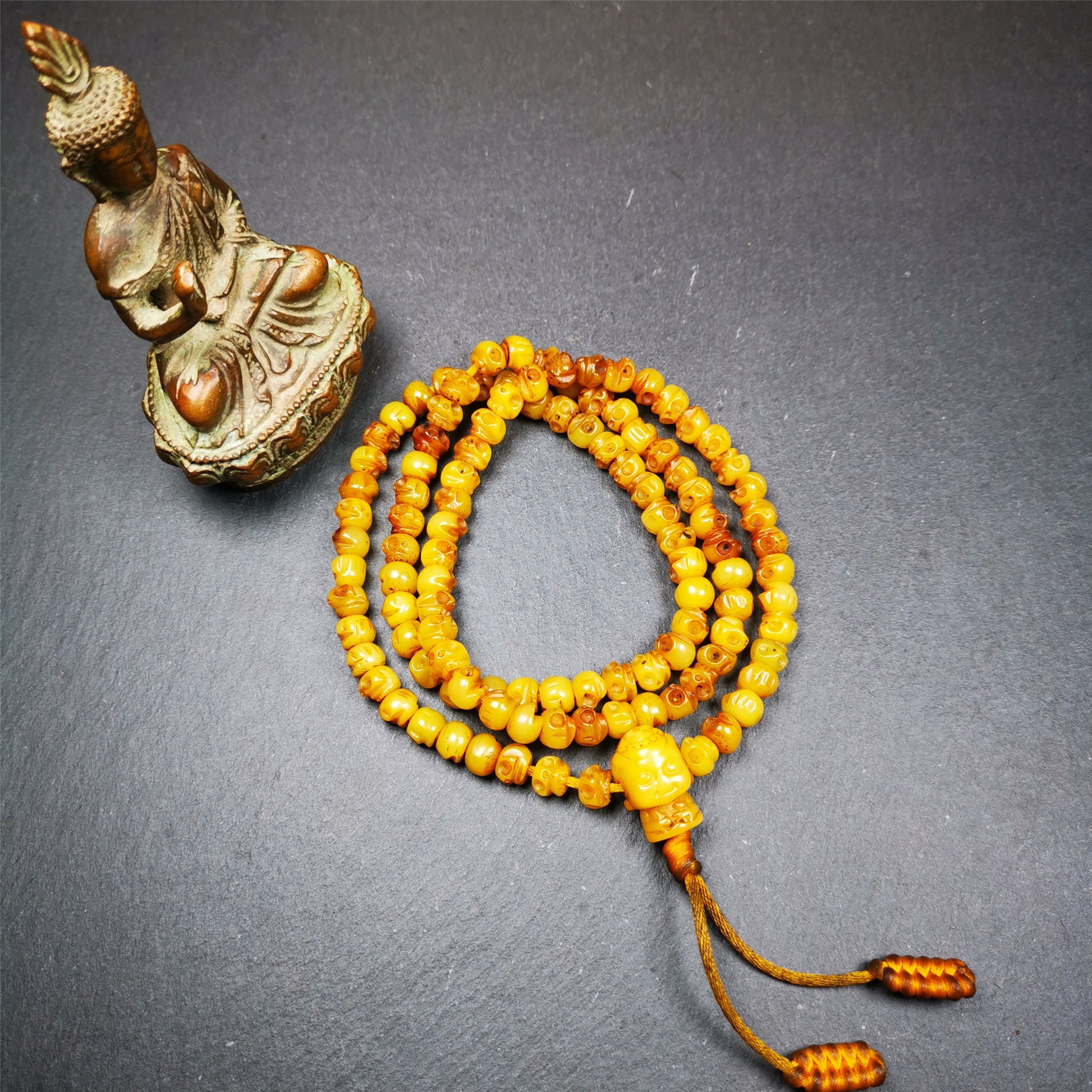 This skull mala was handmade by Tibetan craftsmen.  It is made of yak bone, yellow color,108 skull beads diameter of 7mm / 0.27",circumference is 66cm / 26" ,  end of a yak bone buddha shape guru bead.