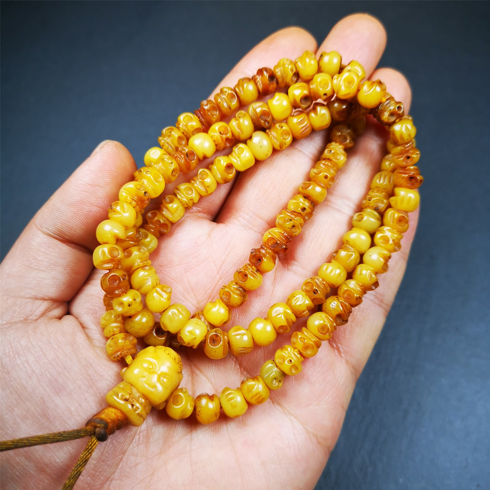 This skull mala was handmade by Tibetan craftsmen.  It is made of yak bone, yellow color,108 skull beads diameter of 7mm / 0.27",circumference is 66cm / 26" ,  end of a yak bone buddha shape guru bead.