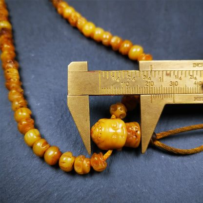 This skull mala was handmade by Tibetan craftsmen.  It is made of yak bone, yellow color,108 skull beads diameter of 7mm / 0.27",circumference is 66cm / 26" ,  end of a yak bone buddha shape guru bead.