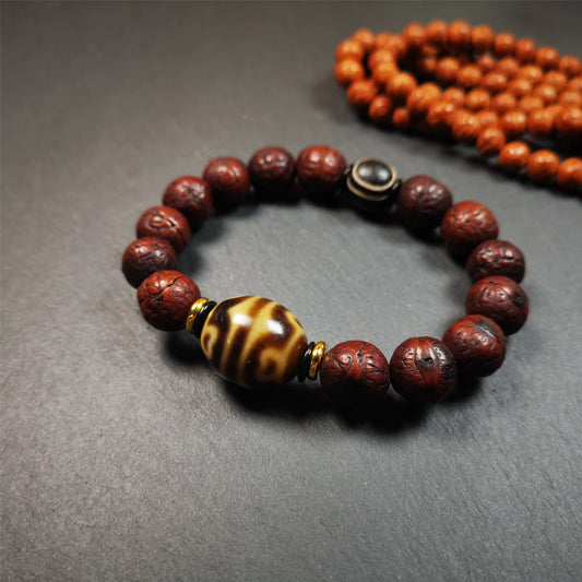 This unique Dalo Dzi bracelet combines the mysterious and unique qualities of the Lotus dalo dzi, stripe pyu dzi, and 14 old bodhi seed beads,giving it a distinct feel. It is brown in color and has a circumference of approximately 7 inches, suitable for most wrist sizes.