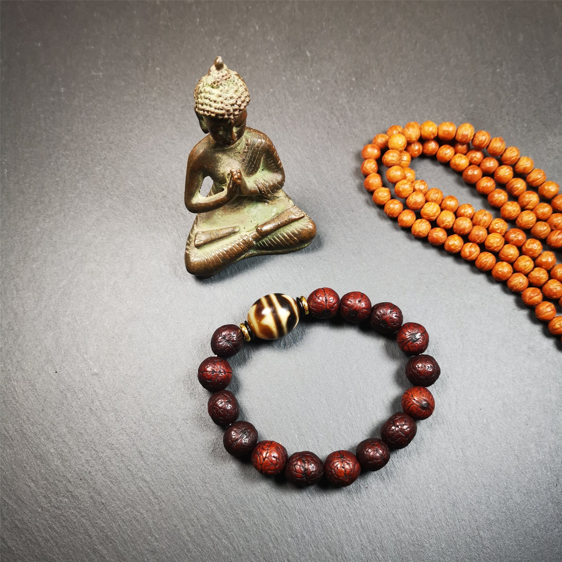 This unique Dalo Dzi bracelet combines the mysterious and unique qualities of the tiger tooth dalo dzi and 15 old bodhi seed beads,giving it a distinct feel.  It is brown in color and has a circumference of approximately 7 inches, suitable for most wrist sizes. 