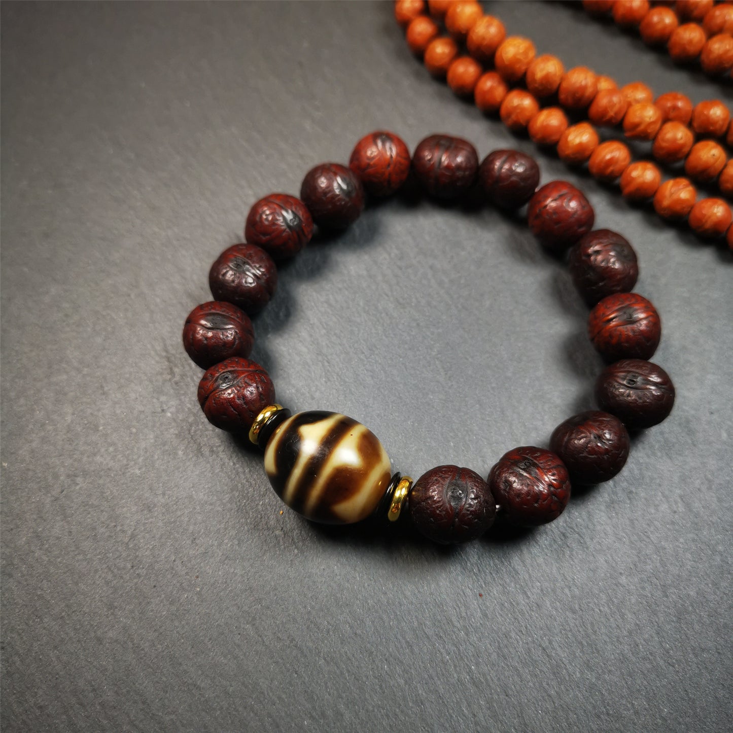 This unique Dalo Dzi bracelet combines the mysterious and unique qualities of the tiger tooth dalo dzi and 15 old bodhi seed beads,giving it a distinct feel.  It is brown in color and has a circumference of approximately 7 inches, suitable for most wrist sizes. 