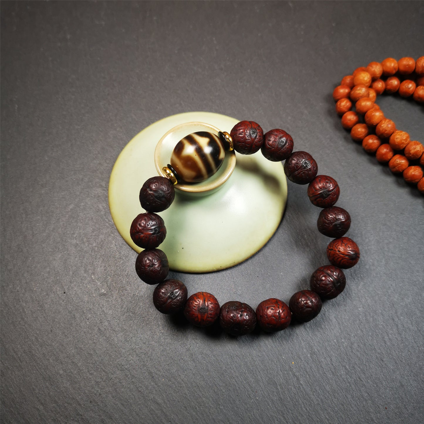 This unique Dalo Dzi bracelet combines the mysterious and unique qualities of the tiger tooth dalo dzi and 15 old bodhi seed beads,giving it a distinct feel.  It is brown in color and has a circumference of approximately 7 inches, suitable for most wrist sizes. 