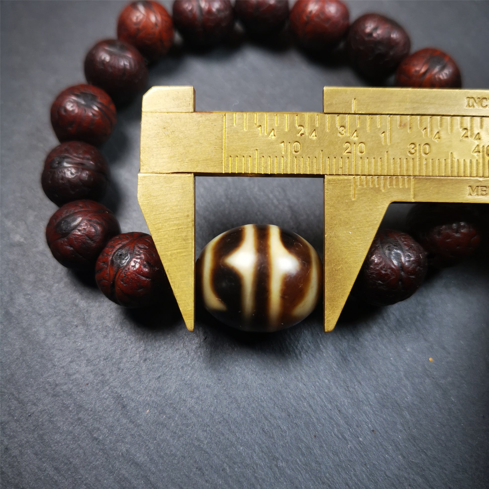 This unique Dalo Dzi bracelet combines the mysterious and unique qualities of the tiger tooth dalo dzi and 15 old bodhi seed beads,giving it a distinct feel.  It is brown in color and has a circumference of approximately 7 inches, suitable for most wrist sizes. 