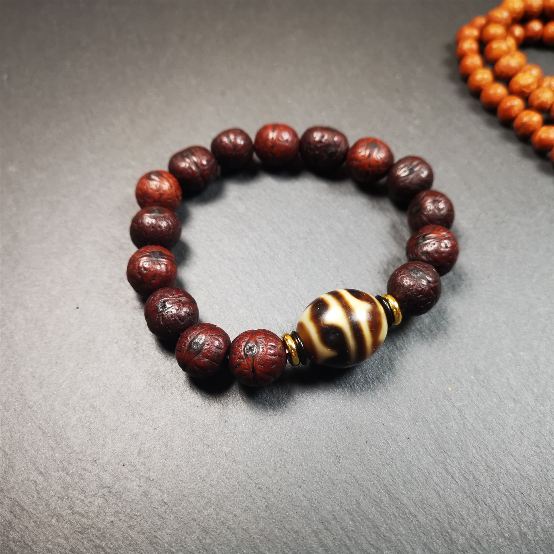 This unique Dalo Dzi bracelet combines the mysterious and unique qualities of the tiger tooth dalo dzi and 15 old bodhi seed beads,giving it a distinct feel.  It is brown in color and has a circumference of approximately 7 inches, suitable for most wrist sizes. 