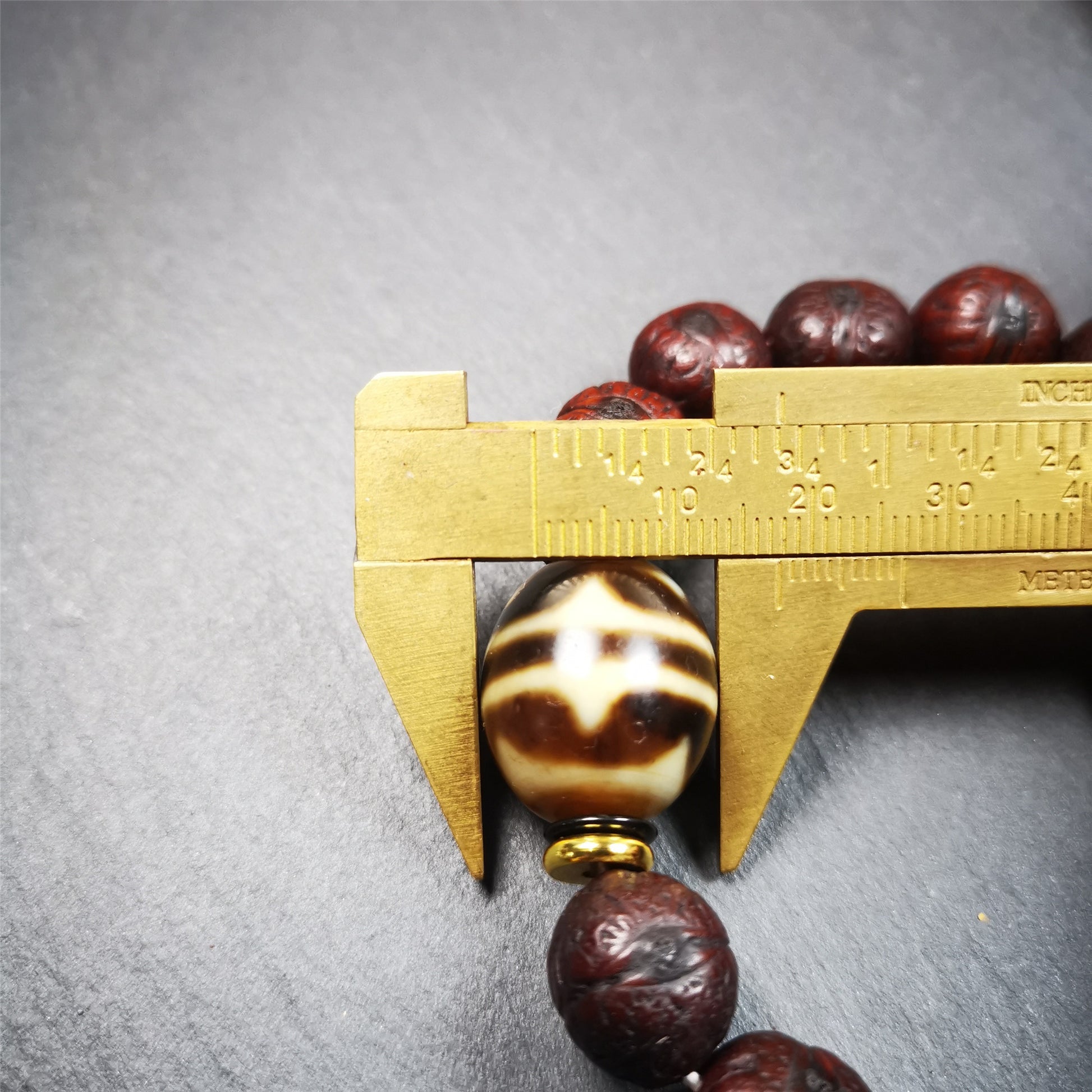 This unique Dalo Dzi bracelet combines the mysterious and unique qualities of the tiger tooth dalo dzi and 15 old bodhi seed beads,giving it a distinct feel.  It is brown in color and has a circumference of approximately 7 inches, suitable for most wrist sizes. 