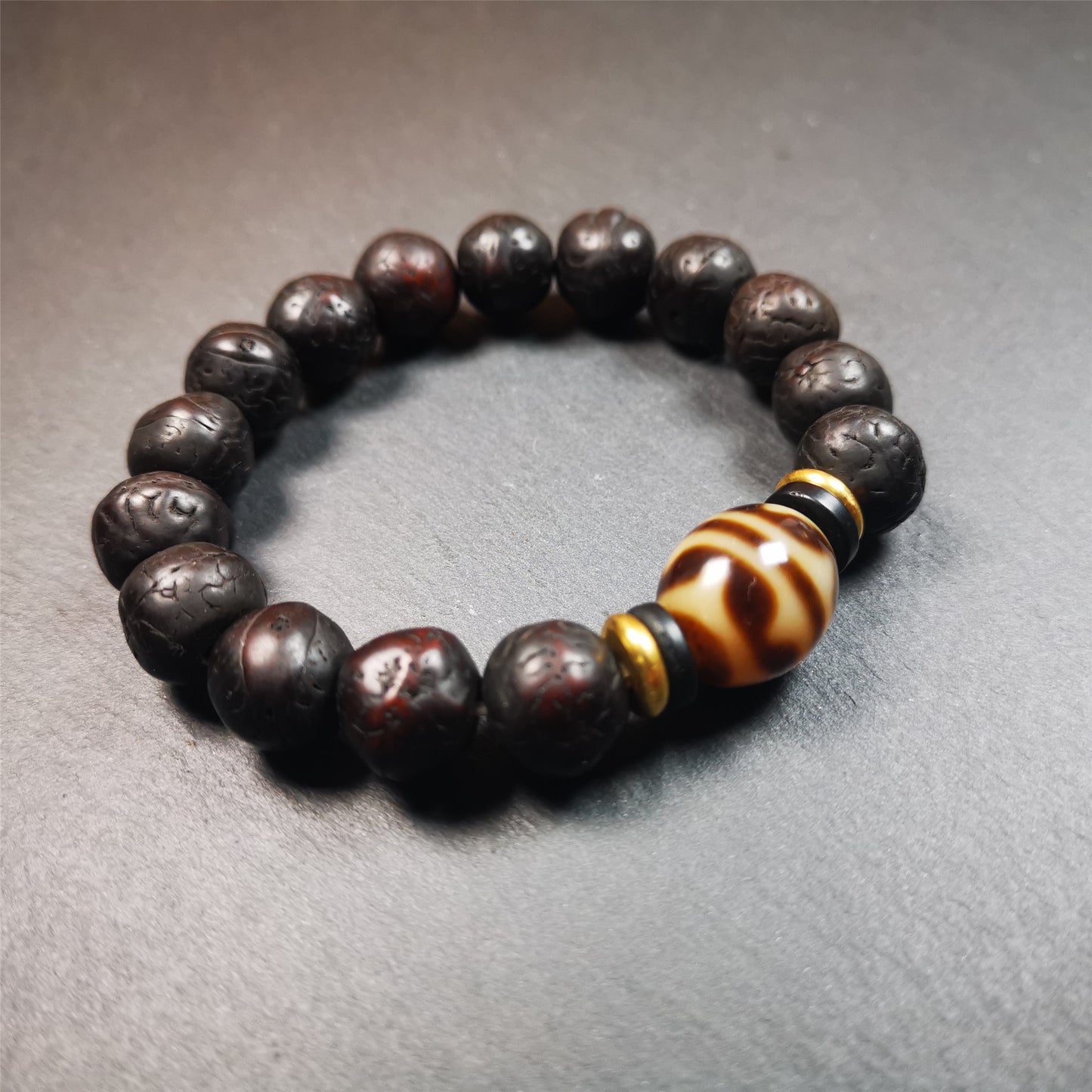This unique Dalo Dzi bracelet is made up of one tiger tooth Dalo Dzi and 15 old bodhi seed beads. It is brown in color and has a circumference of approximately 7 inches, is suitable for most wrist sizes.  This bracelet combines the mysterious and unique qualities of the tiger tooth Dalo Dzi and the bodhi seed beads, giving it a distinct feel. 
