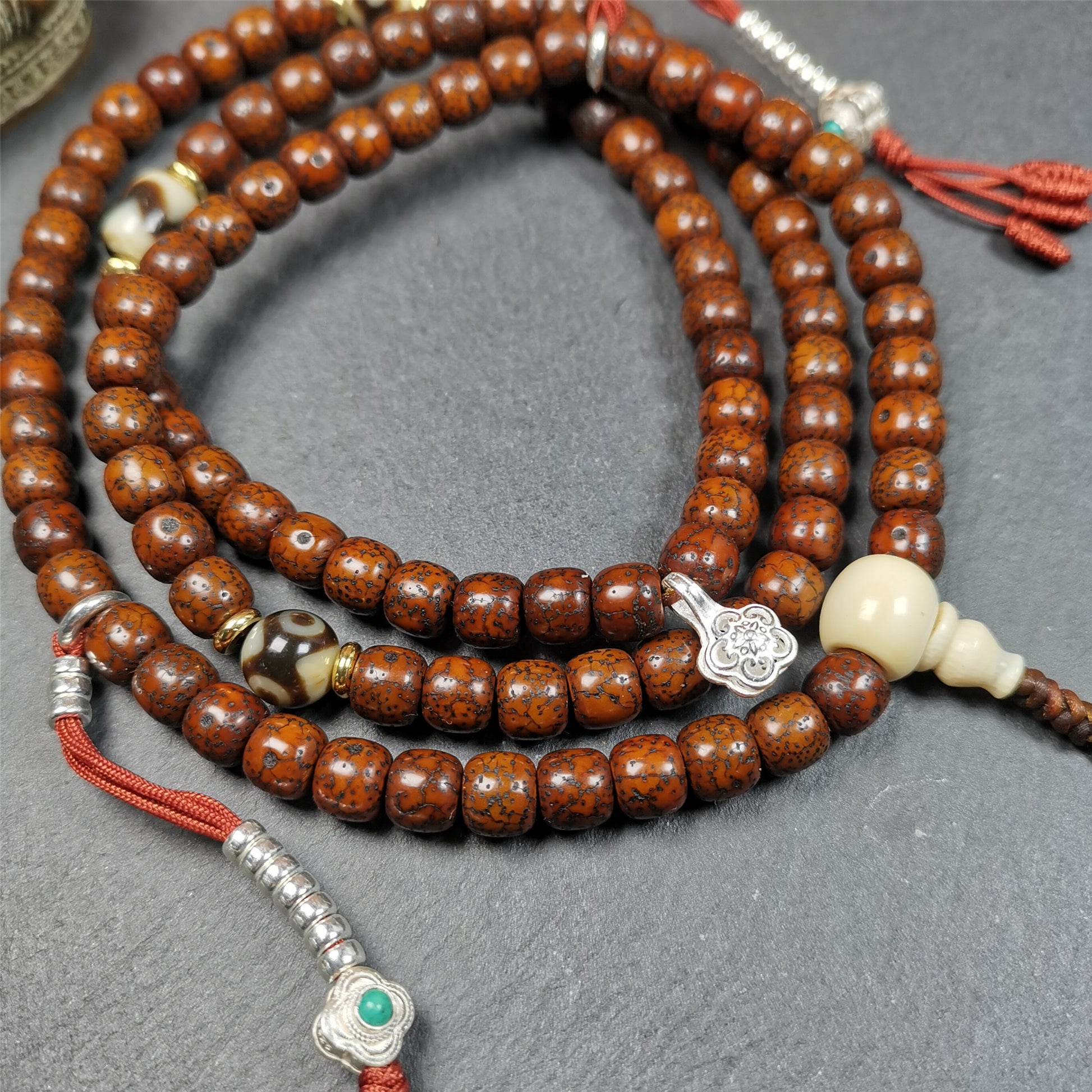  This old lotus seed mala was handmade from tibetan crafts man in Baiyu County,about 30 years old. It's composed of 108 lotus seed beads,then add some dzi beads,1 pair of silver bead counters,and ivory guru bead on i