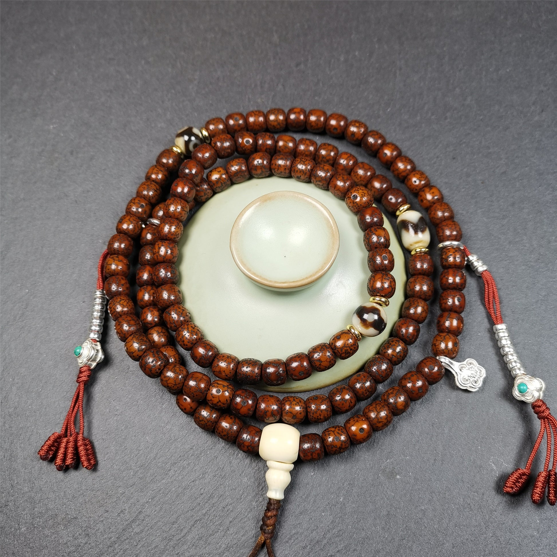  This old lotus seed mala was handmade from tibetan crafts man in Baiyu County,about 30 years old. It's composed of 108 lotus seed beads,then add some dzi beads,1 pair of silver bead counters,and ivory guru bead on i