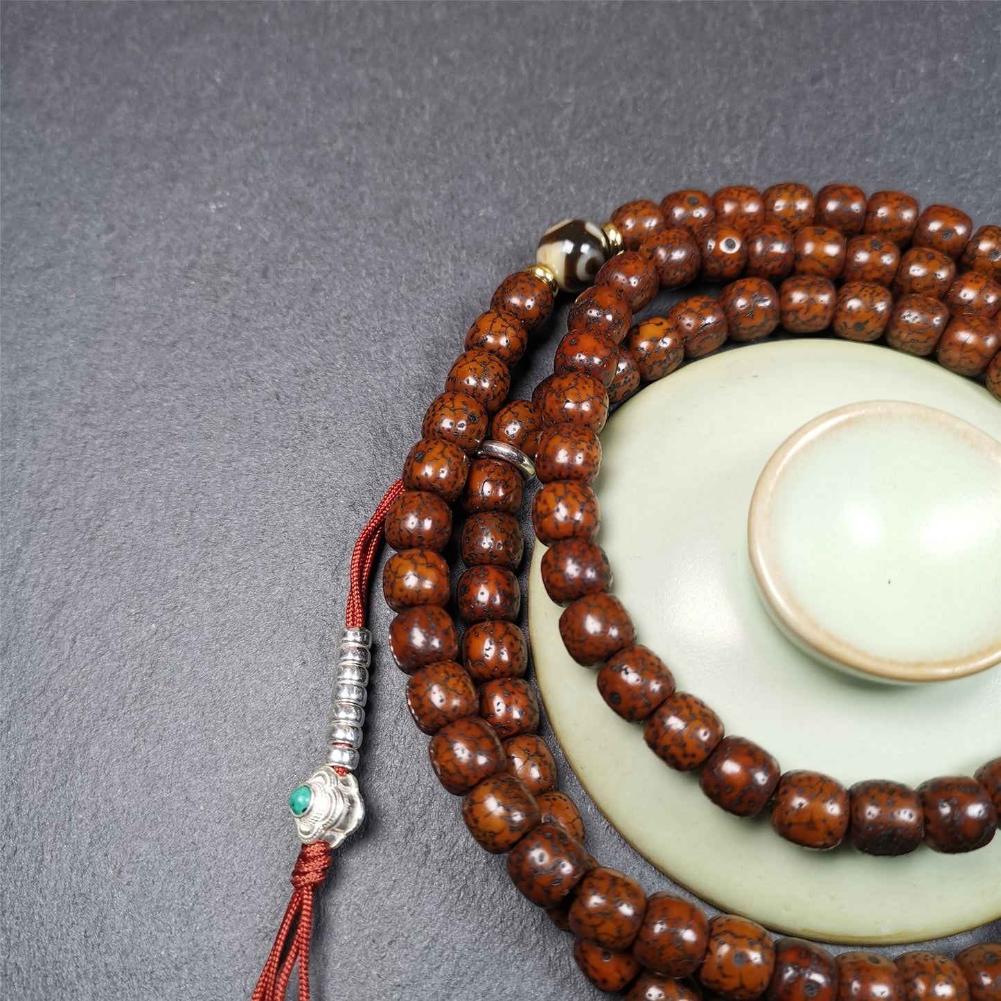  This old lotus seed mala was handmade from tibetan crafts man in Baiyu County,about 30 years old. It's composed of 108 lotus seed beads,then add some dzi beads,1 pair of silver bead counters,and ivory guru bead on i