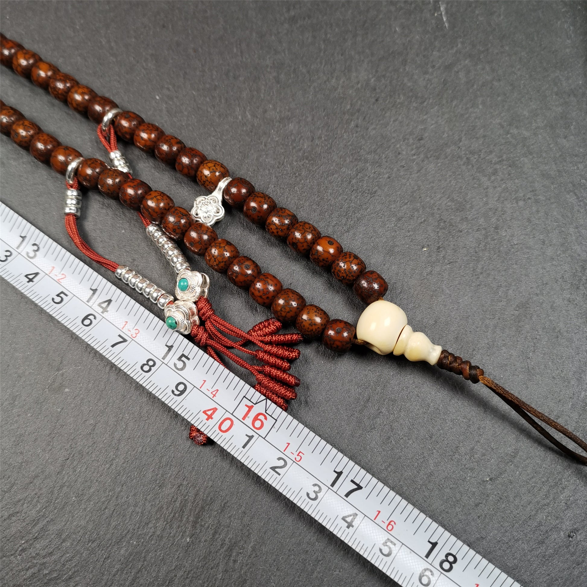  This old lotus seed mala was handmade from tibetan crafts man in Baiyu County,about 30 years old. It's composed of 108 lotus seed beads,then add some dzi beads,1 pair of silver bead counters,and ivory guru bead on i