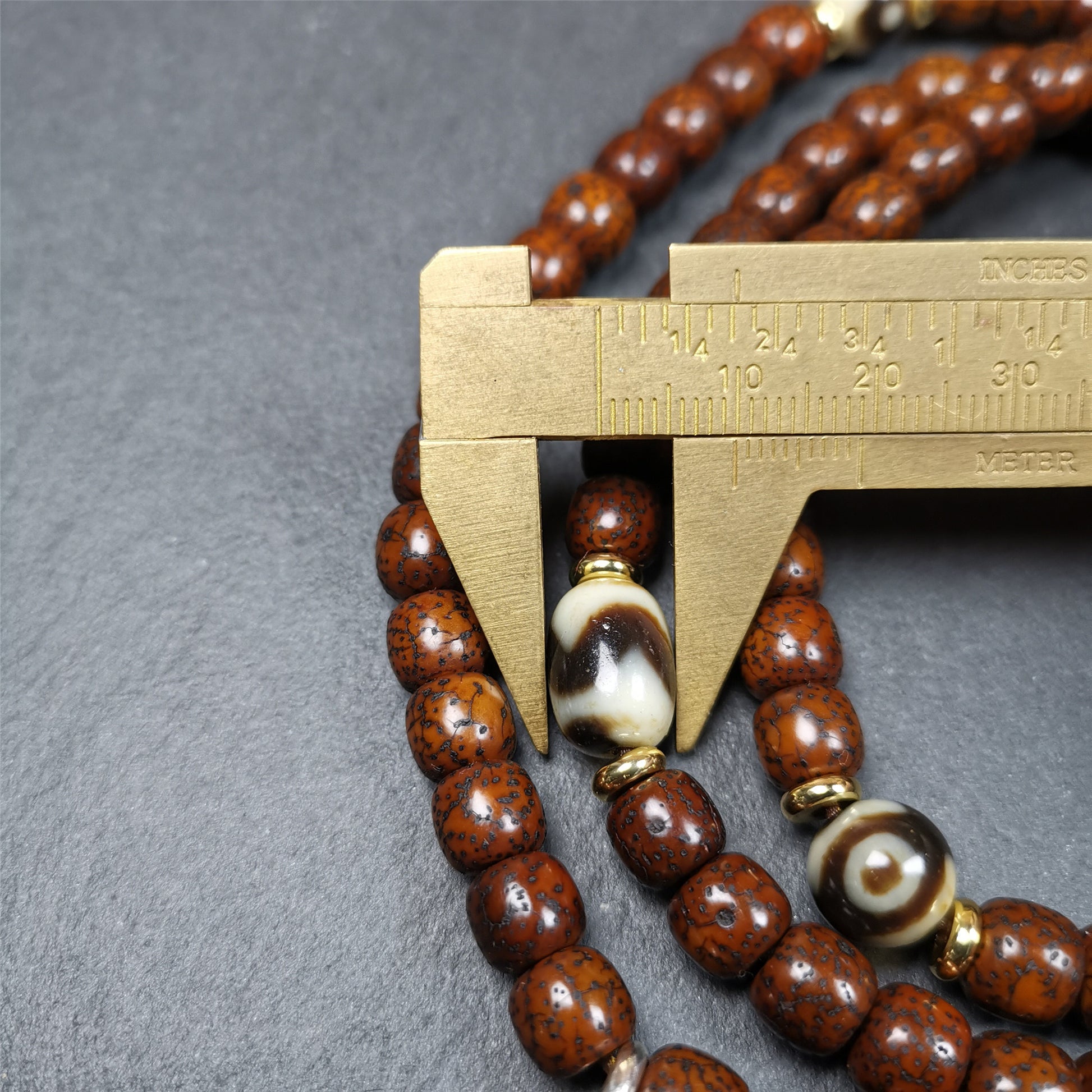  This old lotus seed mala was handmade from tibetan crafts man in Baiyu County,about 30 years old. It's composed of 108 lotus seed beads,then add some dzi beads,1 pair of silver bead counters,and ivory guru bead on i