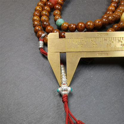 This old lotus seed mala was handmade from tibetan crafts man in Baiyu County,about 30 years old. It's composed of 108 pcs 7mm lotus seed beads,then add some old agate,turquoise beads,1 pair of silver bead counters,and bone guru bead on it.