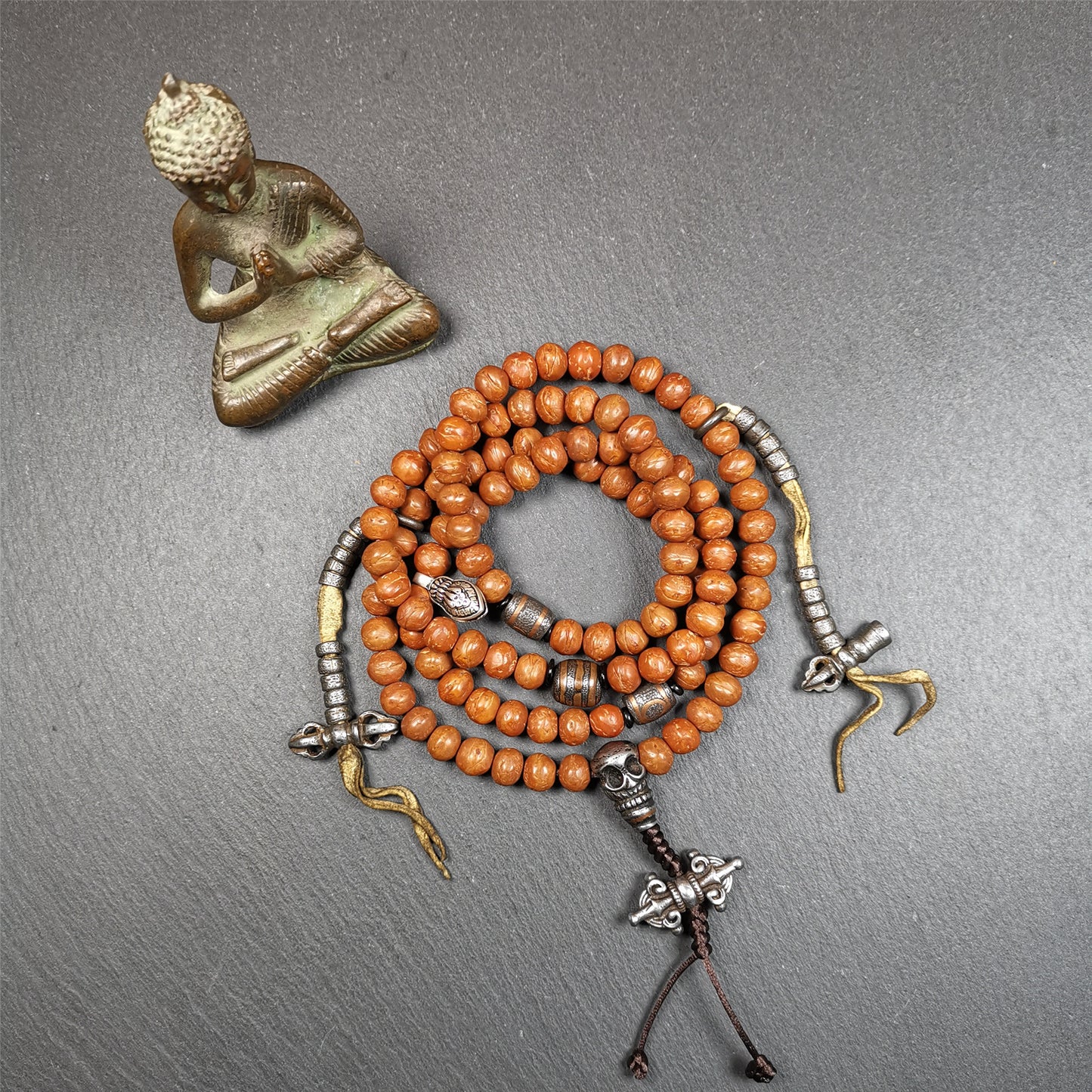 This bodhi beads mala is made by Tibetan craftsmen and come from Hepo Town, Baiyu County, the birthplace of the famous Tibetan handicrafts,about 30 years old, hold and blessed by a lama in Baiyu Monastery.  It is composed of 108 bodhi seed beads, and is equipped with 3 cold iron dzi beads, cold iron bead counters are installed on both sides, 1 mani jewel bead clip,and finally consists a skull guru bead and vajra on the end, very elegant.