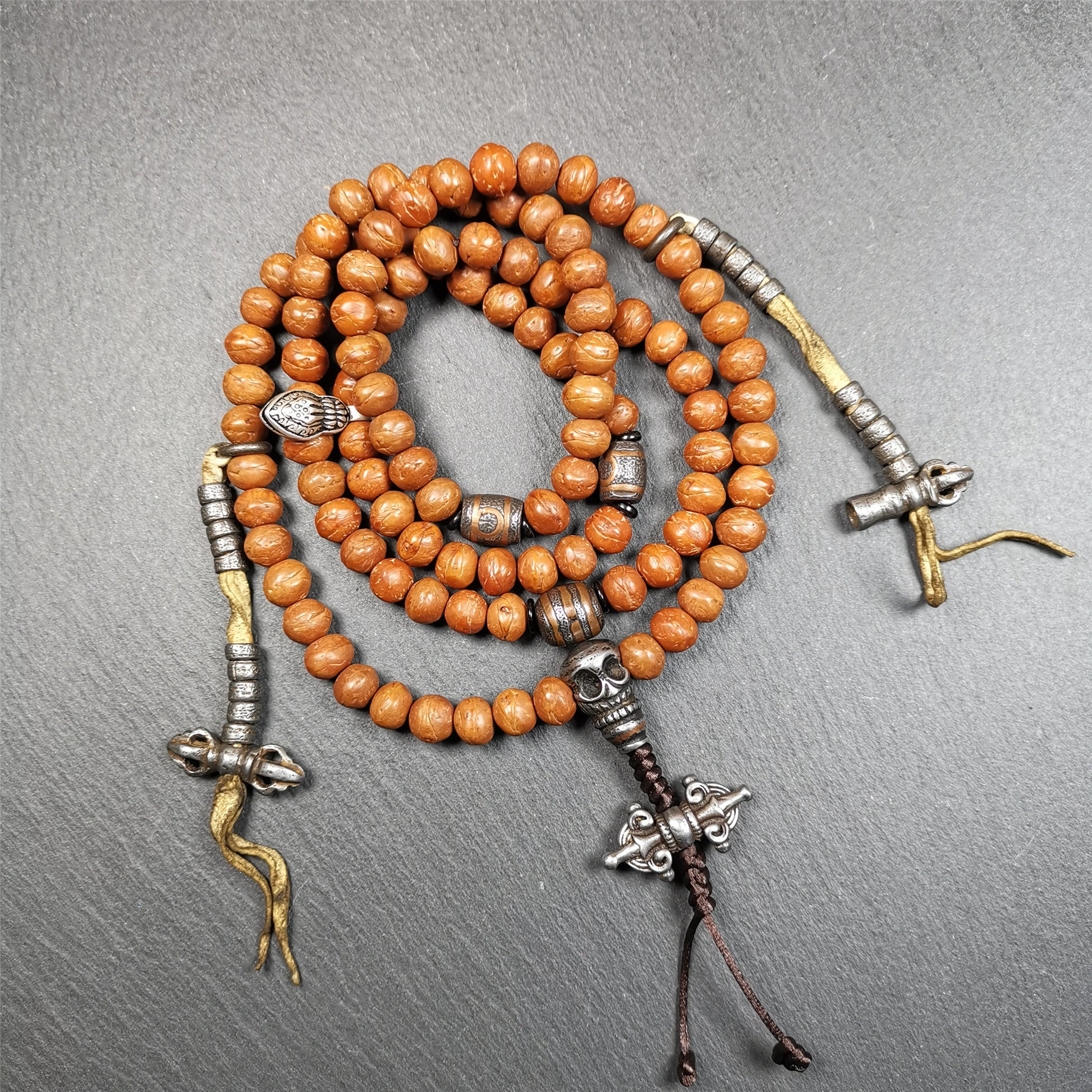 This bodhi beads mala is made by Tibetan craftsmen and come from Hepo Town, Baiyu County, the birthplace of the famous Tibetan handicrafts,about 30 years old, hold and blessed by a lama in Baiyu Monastery.  It is composed of 108 bodhi seed beads, and is equipped with 3 cold iron dzi beads, cold iron bead counters are installed on both sides, 1 mani jewel bead clip,and finally consists a skull guru bead and vajra on the end, very elegant.
