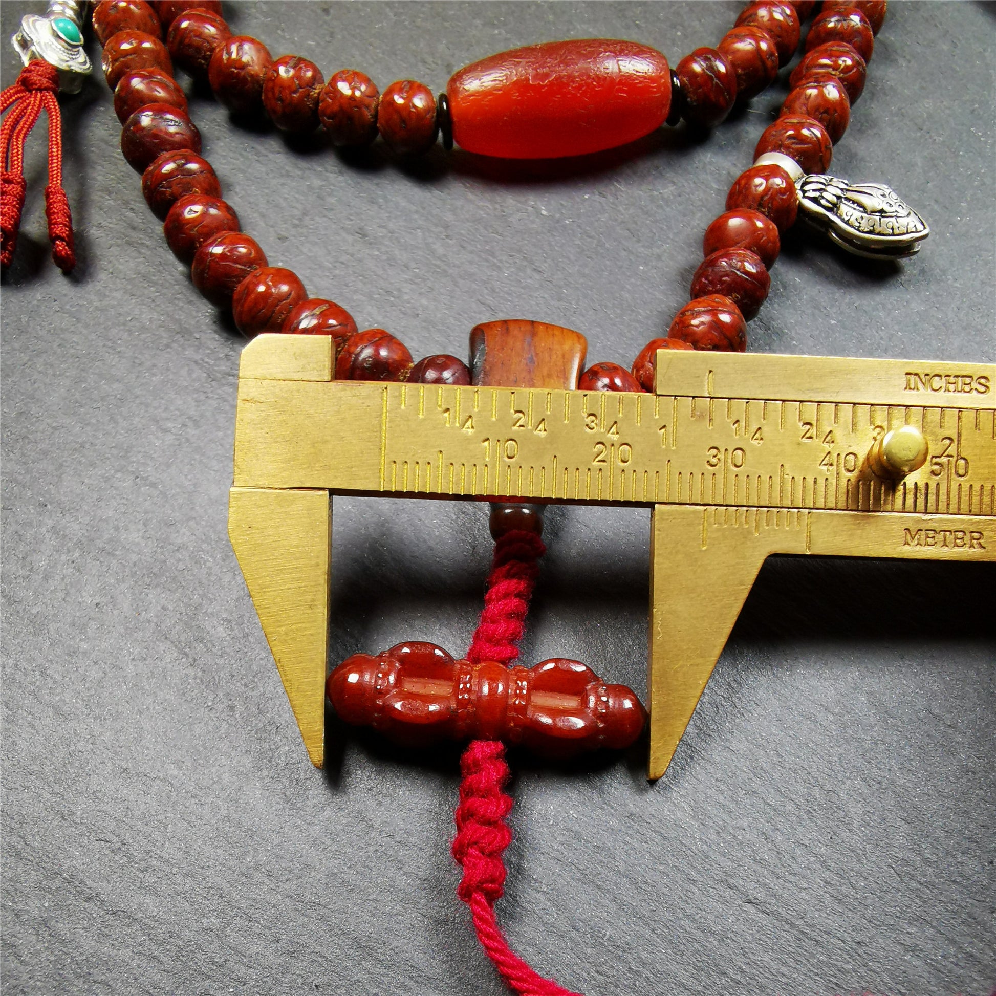 This bodhi beads mala is made by Tibetan craftsmen and come from Hepo Town, Baiyu County, the birthplace of the famous Tibetan handicrafts,about 30 years old, hold and blessed by a lama in Baiyu Monastery.  It is composed of 108 bodhi seed beads, and is equipped with 3 agate beads, silver bead counters are installed on both sides, 1 mani jewel bead clip,and finally consists a bone guru bead and vajra on the end, very elegant.