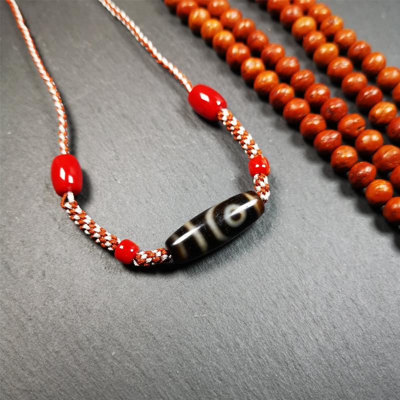 This necklace was hand-woven by Tibetans from Baiyu County, the main bead is a 2 eyed dzi bead, paired with agate beads,about 30 years old. It can be worn as a fashionable accessory, also holds cultural and religious significance.