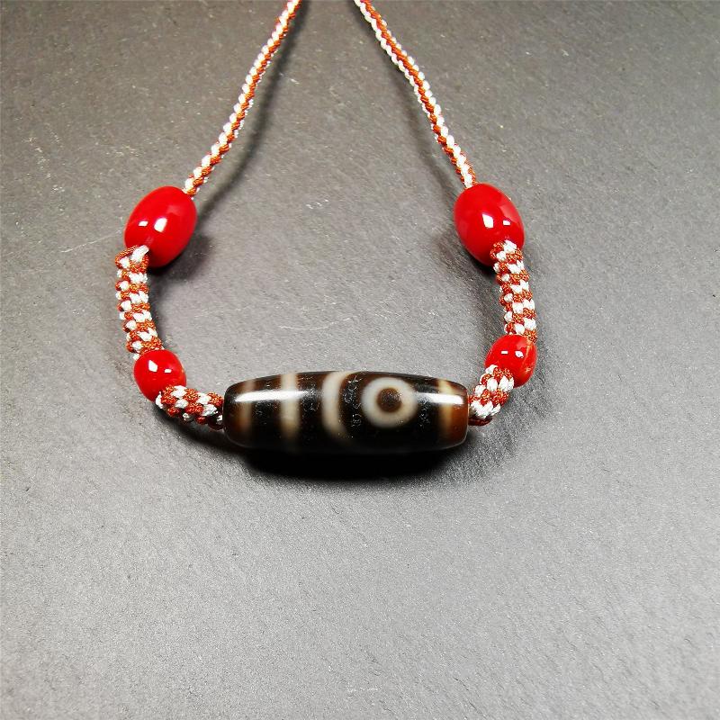 This necklace was hand-woven by Tibetans from Baiyu County, the main bead is a 2 eyed dzi bead, paired with agate beads,about 30 years old. It can be worn as a fashionable accessory, also holds cultural and religious significance.