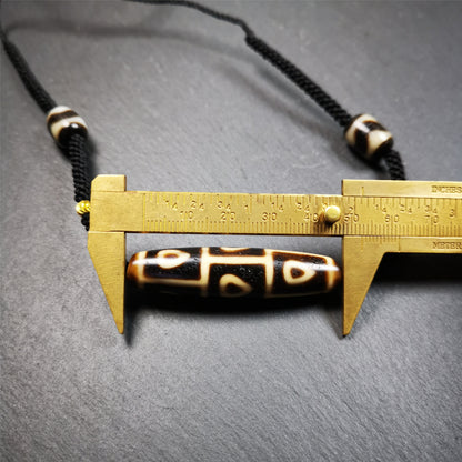 This necklace was hand-woven by Tibetans from Baiyu County, the main bead is a 9 eyed bodhi dzi bead, paired with 2 small tiger tooth dzi beads,about 30 years old. It can be worn as a fashionable accessory,holds cultural and religious significance.