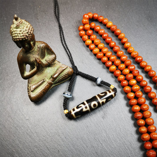 This necklace was hand-woven by Tibetans from Baiyu County, the main bead is a Guru Rinpoche's Ritual Paraphernalia Dzi bead, paired with 2 small stripe dzi beads,about 40 years old. It can be worn not only as a fashionable accessory but also holds cultural and religious significance. The length of the necklace can be adjusted, the maximum circumference is about 60cm.