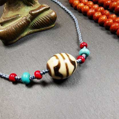 This necklace was hand-woven by Tibetans from Baiyu County, the main bead is a lotus dalo dzi bead, paired with turquoise and agate beads,about 40 years old. It can be worn not only as a fashionable accessory but also holds cultural and religious significance. The length of the necklace can be adjusted, the maximum circumference is about 60cm.