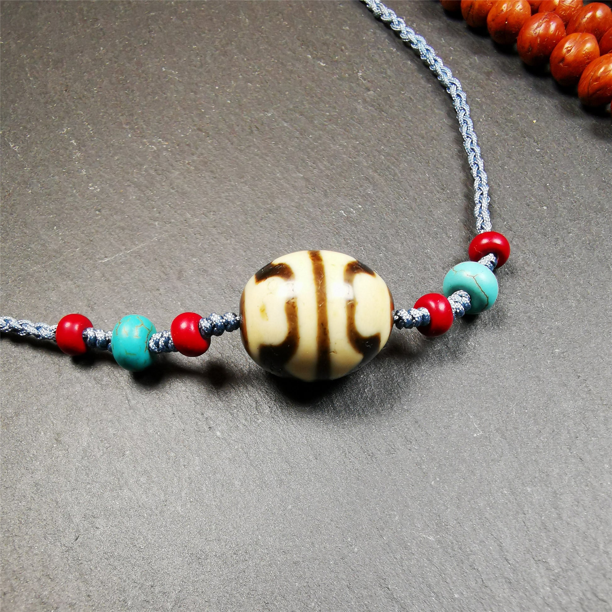 This necklace was hand-woven by Tibetans from Baiyu County, the main bead is a lotus dalo dzi bead, paired with turquoise and agate beads,about 40 years old. It can be worn not only as a fashionable accessory but also holds cultural and religious significance. The length of the necklace can be adjusted, the maximum circumference is about 60cm.